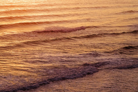 Ocean waves in warm sunset light, natural backgroundの写真素材