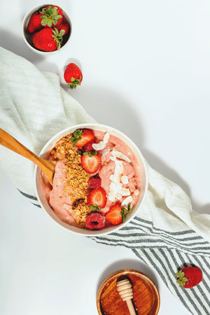Berry smoothie bowl topped with strawberries, raspberries, and granola for a healthy breakfastの写真素材