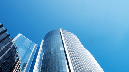 Modern skyscrapers reaching towards a clear blue sky in a busy urban setting, business backgroundの写真素材