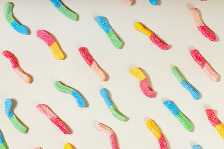 Colorful gummy candies arranged in a playful pattern on a light backgroundの写真素材