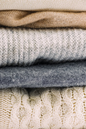Close-up of a pile of cozy warm winter sweaters in neutral colorsの写真素材