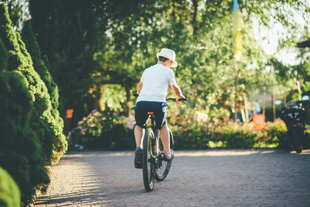 young boy is cycling in the park sunny dayの写真素材