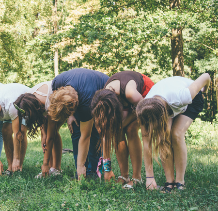 teambuilding exercises with people in the forest holding hands and legsの写真素材