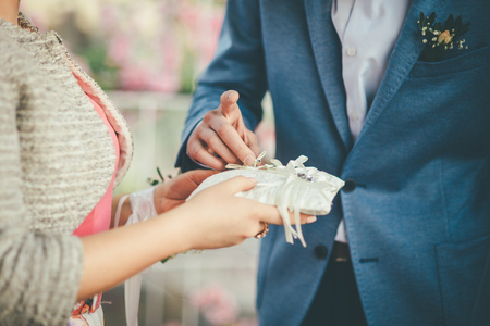 bridegroom is taking wedding ring in blue suit to wear it to the brideの写真素材