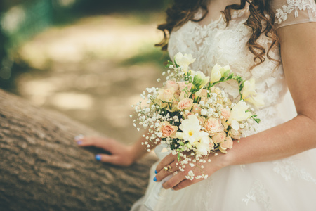 groom is staying holding wedding flowers in wedding dressの写真素材