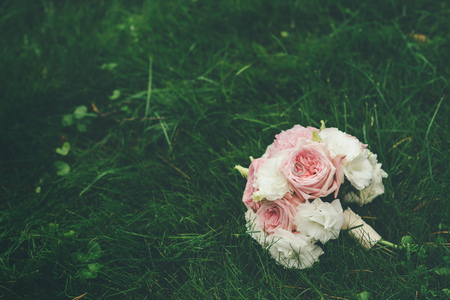 Wedding bouquet of pink and white roses lying on grassの写真素材