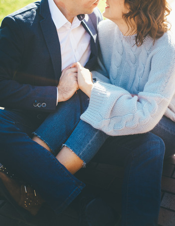Couple of two amazing lovebirds sits closely and hold their hands, while smiling to each otherの写真素材