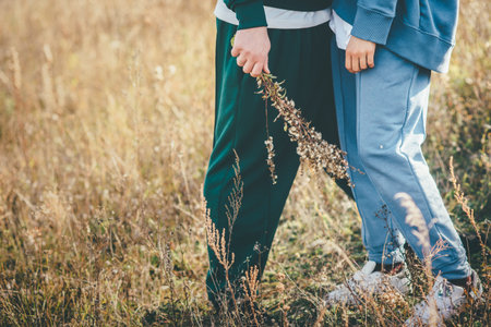 Cute couple in sweatpants share the moments of love in the golden field