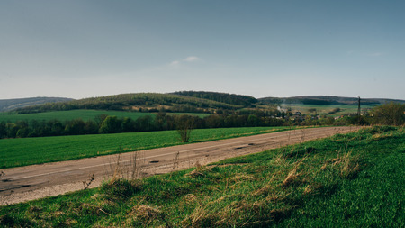 Amazing landscape of the country road placed near the green hills and small villageの写真素材