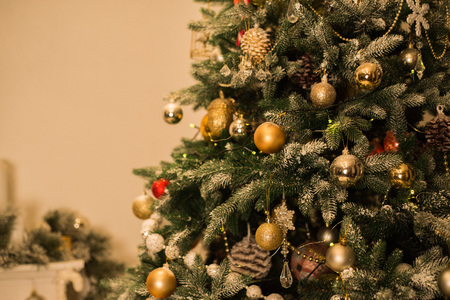 Part of the Christmas tree in focus, fireplace on the background, all decorated in warm shadesの写真素材