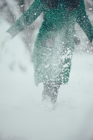 woman is running in fluffy flaky snow and enjoys winter weatherの写真素材