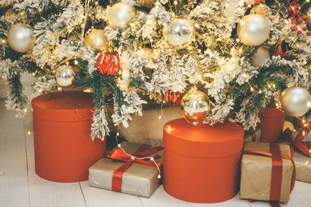Different Christmas presents under the celebration tree, which is decorated in classic styleの写真素材