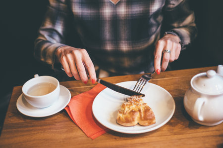 woman is eatting pie and drink coffee with knife anf fork