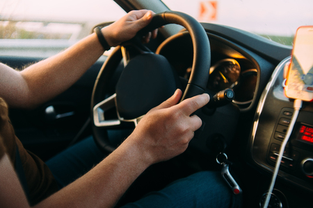 man is driving car hands on the wheel sunset sunriseの写真素材