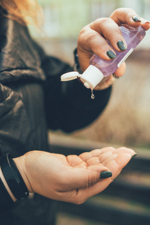 Woman cleaning hands for stop corona with alcohol antiseptic outdoor close up