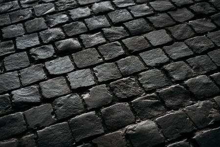 Black texture of the road. Stoned wet blocks.の写真素材