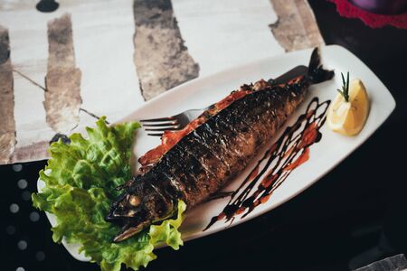 baked mackerel with greens in the restaurantの写真素材