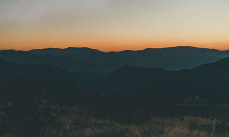 Beautiful orange sunrise in the mountains. Mountain ranges, fog.の写真素材