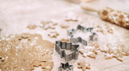 Gingerbread dough with flour on a table and christmas cookie cuttersの写真素材