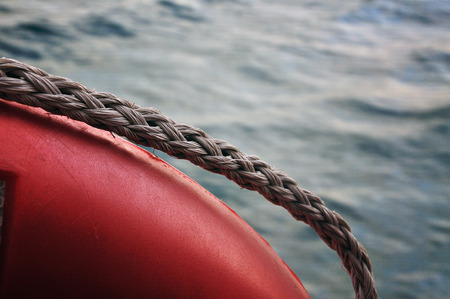 Red life buoy on sea background photographed from a boatの写真素材