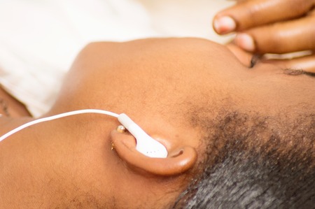 Young woman lying with an earpiece to the ear.の写真素材