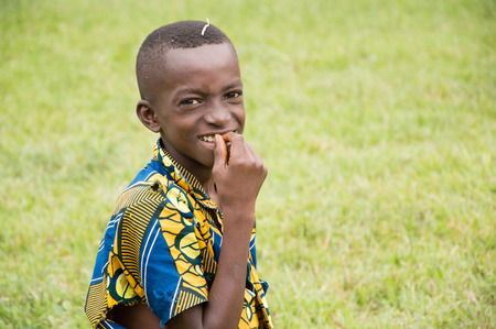 Anekro, Ivory coast-august 20.2015: an african child smiling and lying down camera.this the child, finger on the teeth with a smile, joy at His Manifested Being photographedのeditorial素材