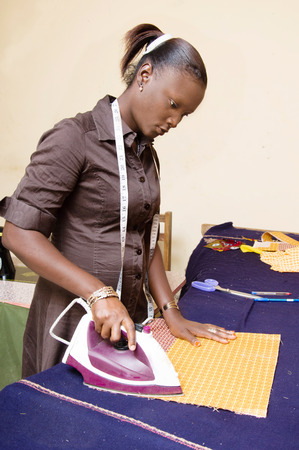 young woman ironing fabricの写真素材