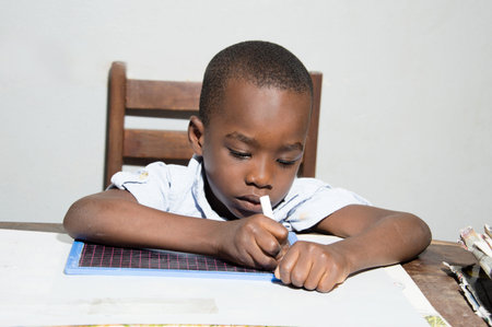 This child written with a chalk stick in hand.の写真素材