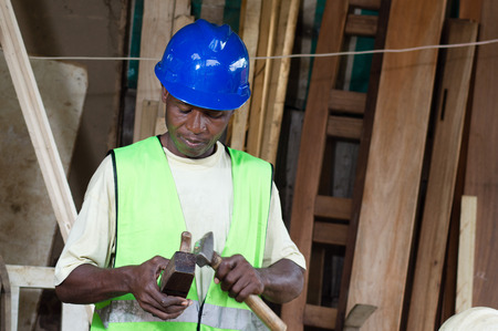 The carpenter takes His plane in hand and check the bladeの写真素材