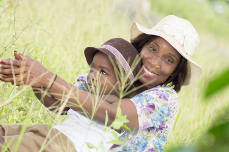 young woman and her child playing in the grass.の写真素材