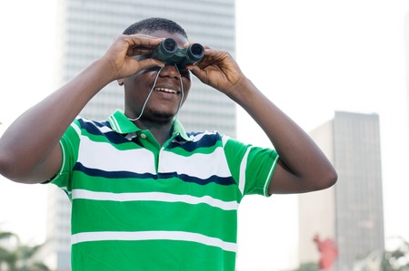 young businessman looks through binoculars to signify That he is looking for paths to success.の写真素材