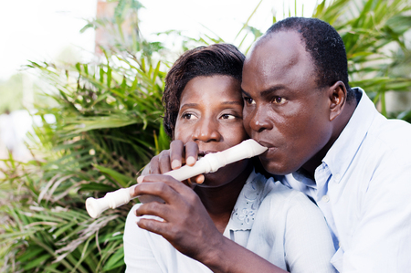 adult couple in love sitting by the side of a flower, and play the flute.の写真素材