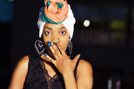 Young woman expressing surprise by putting her hand on his mouth.の写真素材