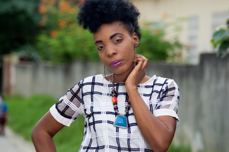 Beautiful young woman posing outdoors with hand around her neckの写真素材
