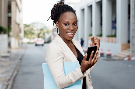 Young businesswoman manifesting her joy when she saw a transfer in her smart phone.の写真素材