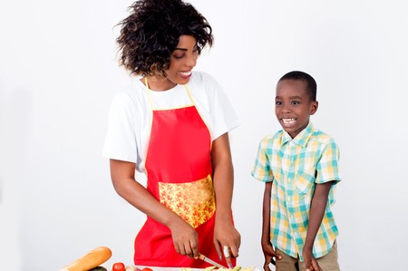 Happy young woman shows her son how to make a vegetable meal that makes him so happyの写真素材