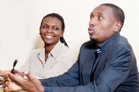 Young woman sitting side by side with her partner, looks at him and laughs.の写真素材