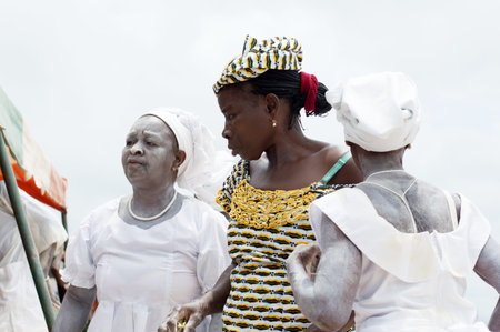 adzopÃ©, ivory coast-aug. 31, 2016: mature women standing dressed in white powder on the body of...