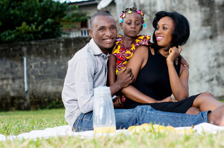 happy parents playing in the park with their daughter
