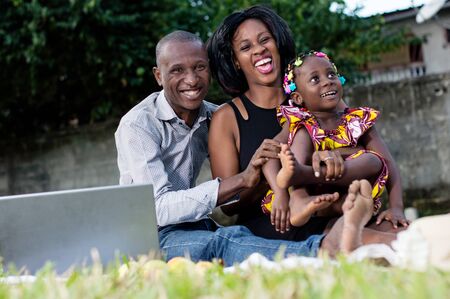 happy parents playing in the park with their daughterの写真素材
