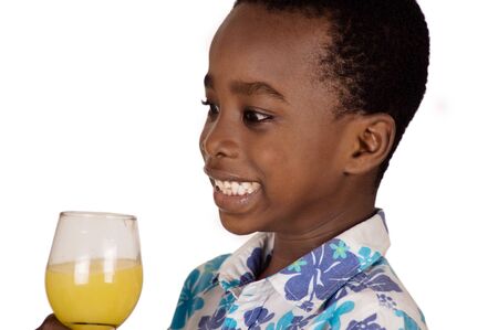 Little boy isolated on white background is happy to drink fruit juice in the glass he holds.の写真素材