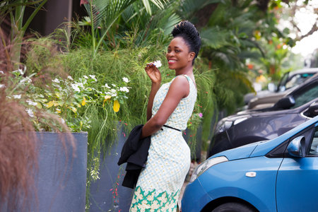 young happy businesswoman standing on the street and holding a white flower in the handの写真素材