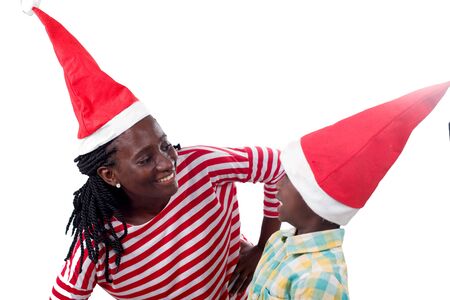 Happy mother is watching over her happy child all with Santa Claus hats and isolated on white background.の写真素材