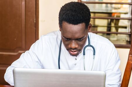 doctor with stethoscope and working on his laptop at the office.の写真素材