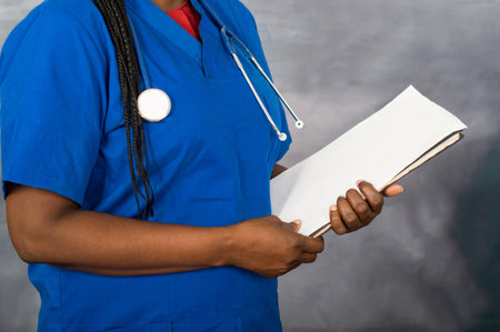 a young nurse standing with stethoscope on her neck and holding a document on her arm.
