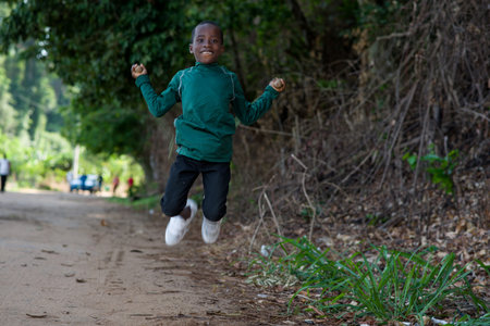 young boy in sportswear jumping rope and looking at camera smiling.