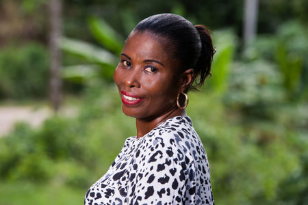 young woman standing in black white shirt looking at camera smiling.
