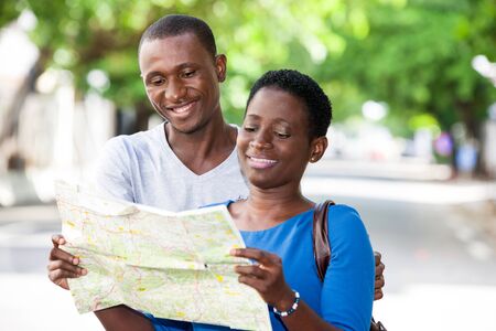 Young people standing in the street looking at map geographical smiling.の写真素材