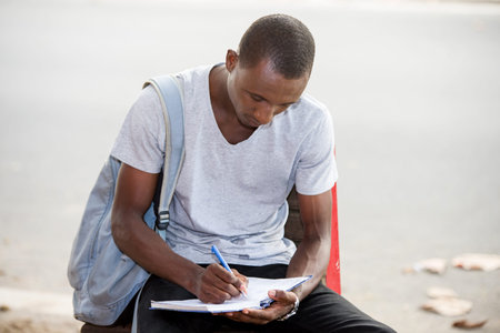 young student, a man studying sitting in town after school