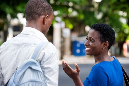 young girl standing in blue camisole talking to her friend smiling.の写真素材